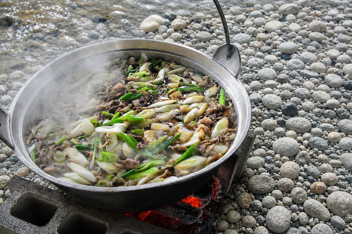 河原の石組みコンロで煮る山形の芋煮（土垂・牛肉・長ねぎ・しょうゆ）